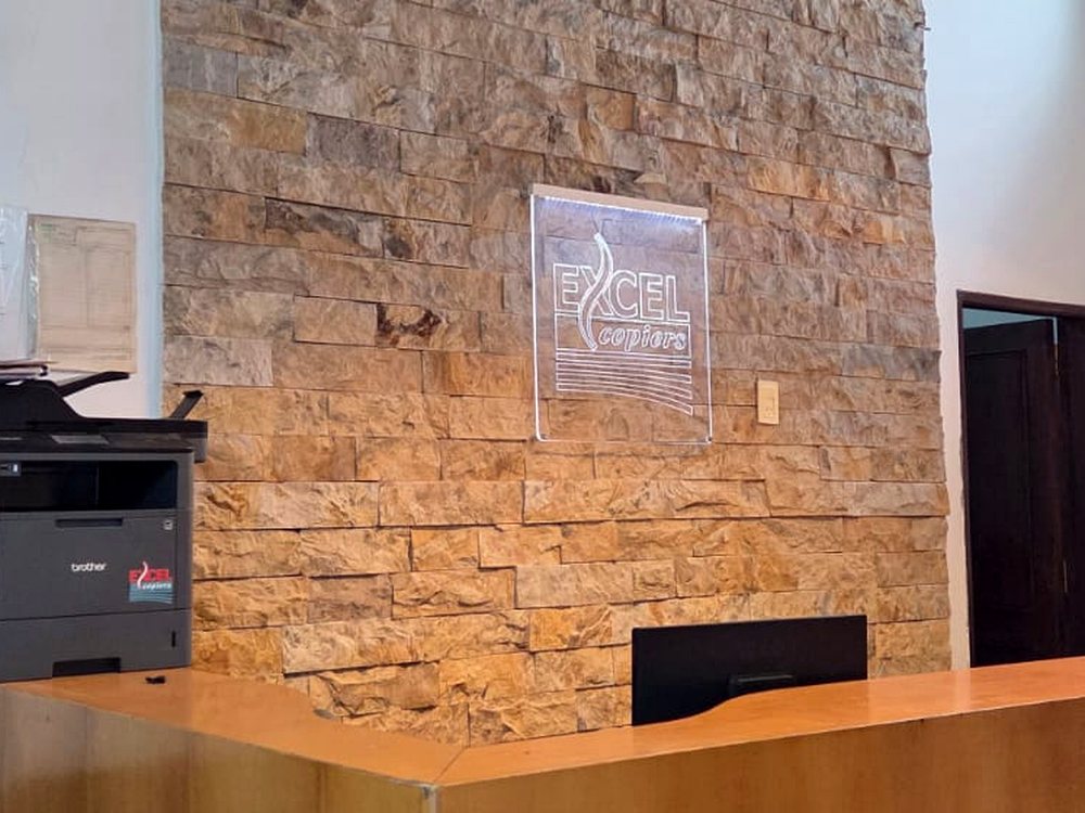 Recepción Excel Copiers con logo en pared